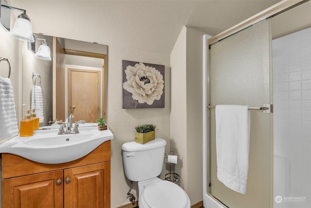 bathroom with walk in shower, vanity, and toilet