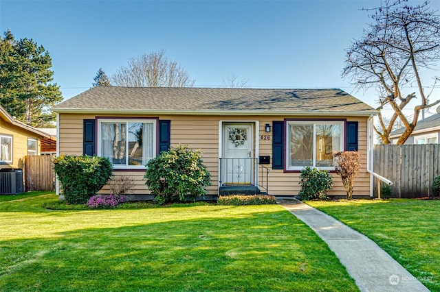 bungalow-style home featuring central AC and a front yard