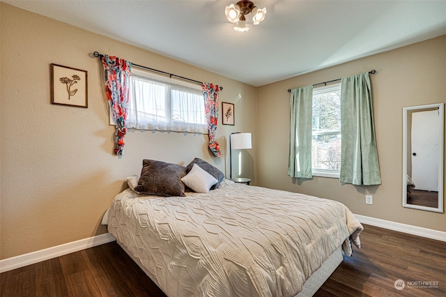 bedroom featuring dark hardwood / wood-style floors and multiple windows