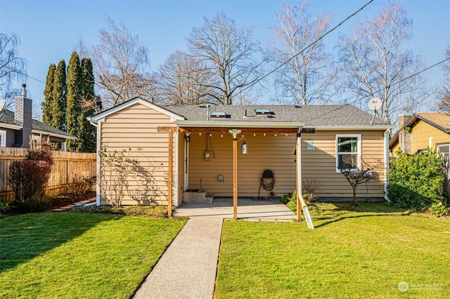 rear view of house featuring a yard and a patio