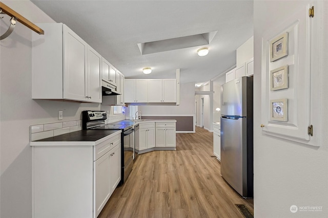 kitchen featuring stainless steel appliances, sink, white cabinets, and light hardwood / wood-style flooring