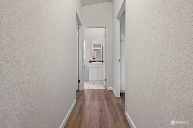 corridor with hardwood / wood-style flooring