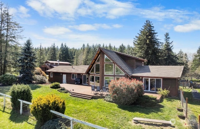 rear view of house with a deck and a lawn