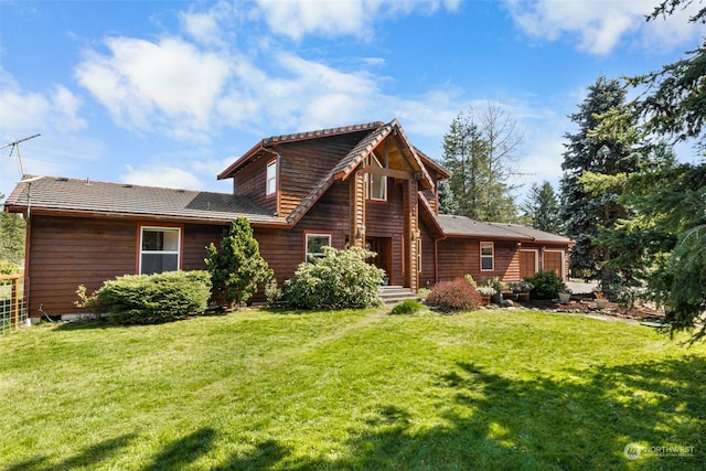 rear view of house featuring a yard