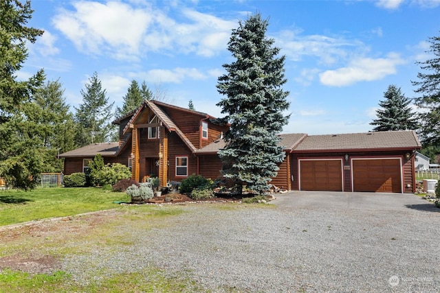 cabin featuring a garage and a front yard