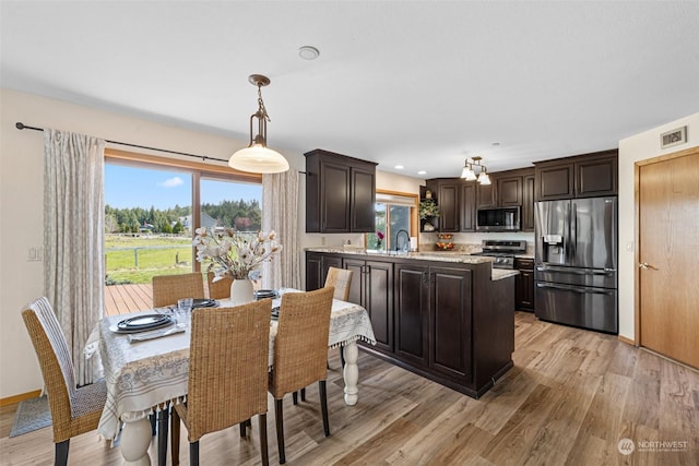 dining room featuring sink and light hardwood / wood-style flooring