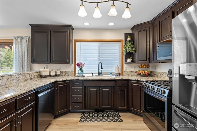 kitchen with pendant lighting, appliances with stainless steel finishes, sink, and dark brown cabinets