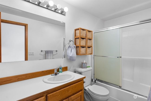 full bathroom with vanity, enclosed tub / shower combo, and toilet