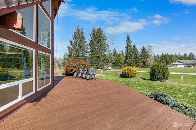 wooden terrace featuring a lawn