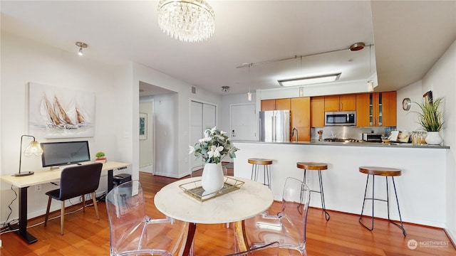 dining area with a notable chandelier and light wood-type flooring