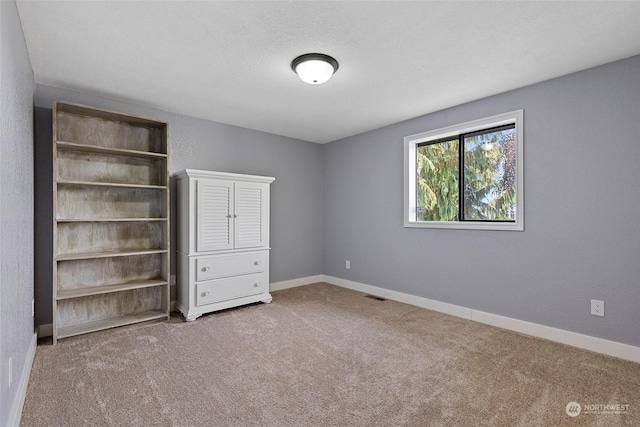 unfurnished bedroom featuring carpet and a textured ceiling