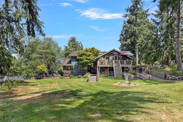 rear view of house with a yard and a deck