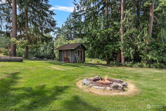 view of yard featuring an outdoor fire pit and an outdoor structure