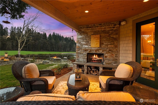 patio terrace at dusk with an outdoor living space with a fireplace