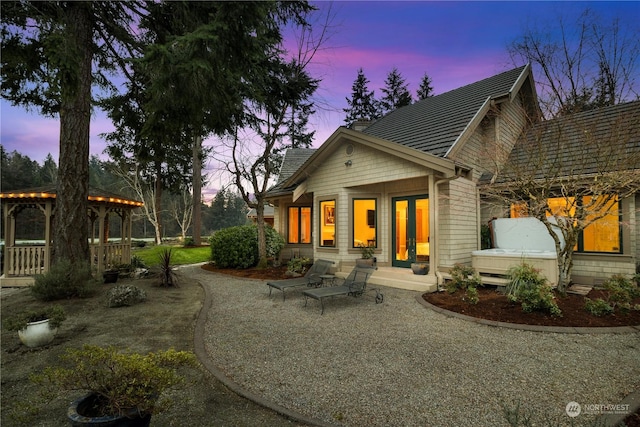 back house at dusk featuring a patio area