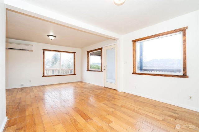 spare room featuring light hardwood / wood-style floors and a wall mounted AC