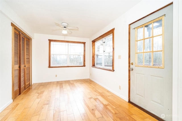 foyer featuring ceiling fan, light hardwood / wood-style floors, and a wealth of natural light