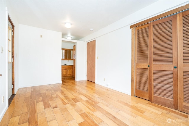 unfurnished bedroom with light hardwood / wood-style floors and a closet