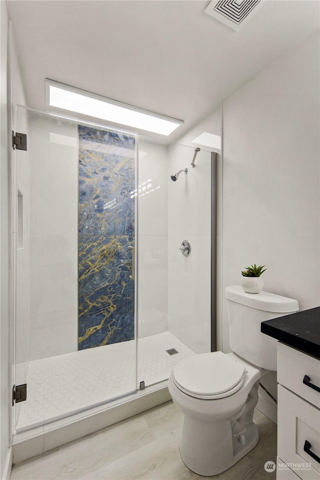 bathroom with vanity, an enclosed shower, and toilet