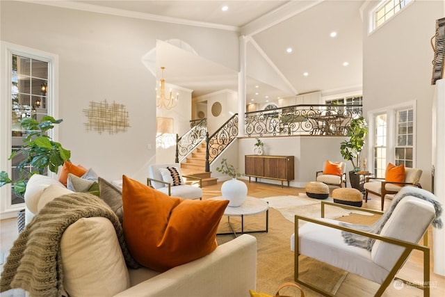 living room with high vaulted ceiling, beamed ceiling, a chandelier, light hardwood / wood-style floors, and crown molding