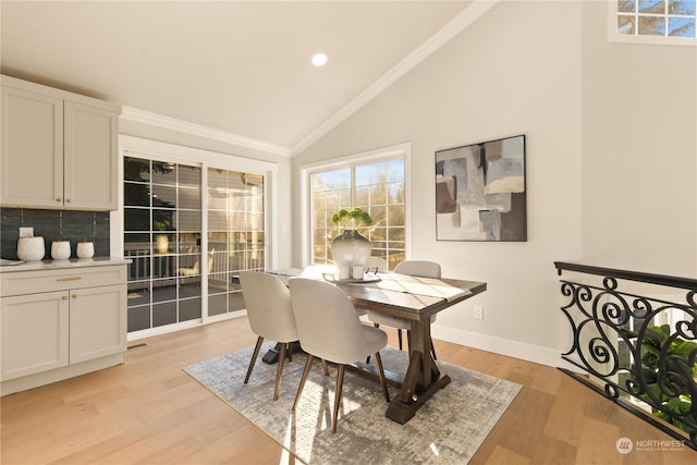 dining area featuring lofted ceiling, crown molding, and light hardwood / wood-style flooring