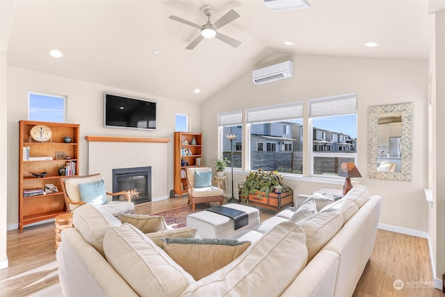 living room featuring a wall mounted air conditioner, vaulted ceiling, ceiling fan, and light wood-type flooring