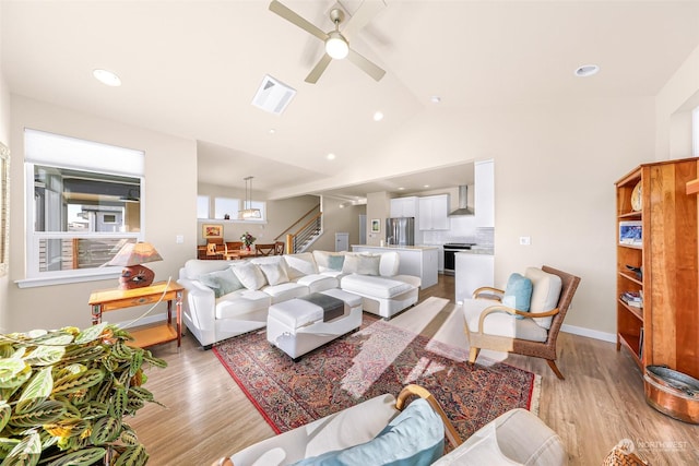 living room featuring lofted ceiling, light hardwood / wood-style flooring, and ceiling fan