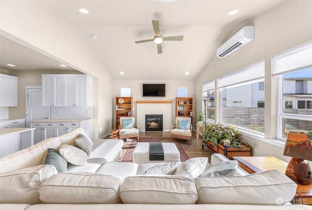 living room featuring wood-type flooring, lofted ceiling, a wall mounted AC, and ceiling fan