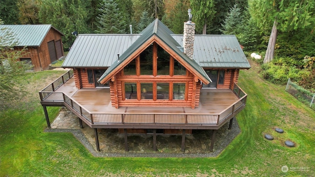 back of house with an outbuilding, a wooden deck, a yard, and a garage