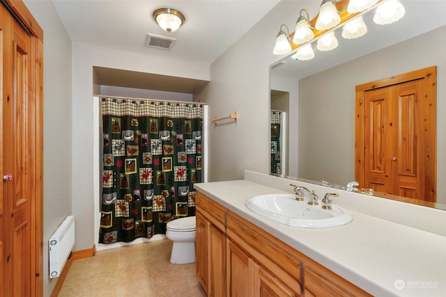 bathroom with vanity, radiator, and toilet