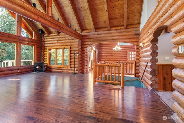 unfurnished living room with wood ceiling, wood-type flooring, beamed ceiling, a chandelier, and a wood stove