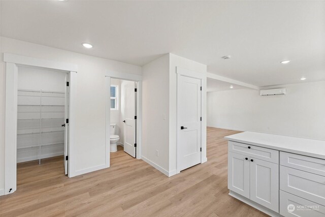 interior space featuring a wall mounted AC and light hardwood / wood-style flooring