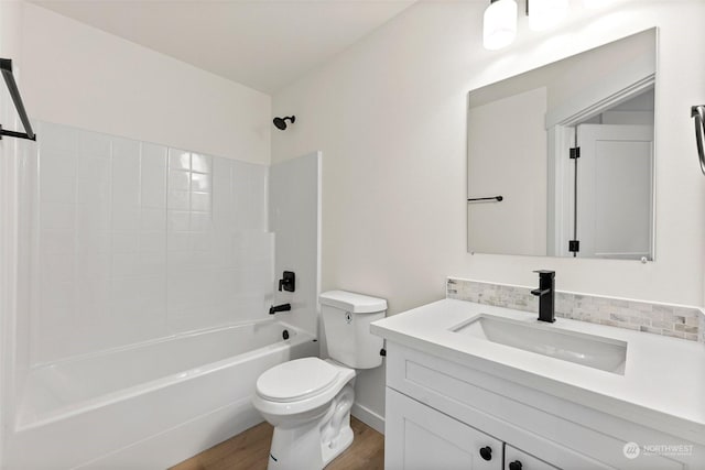 full bathroom featuring hardwood / wood-style floors, bathtub / shower combination, backsplash, vanity, and toilet