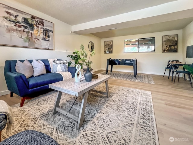 living room featuring wood-type flooring and a textured ceiling