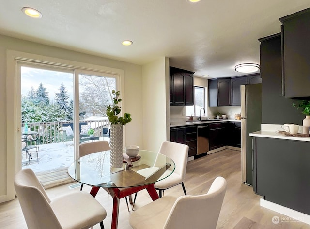 dining space with sink and light hardwood / wood-style floors