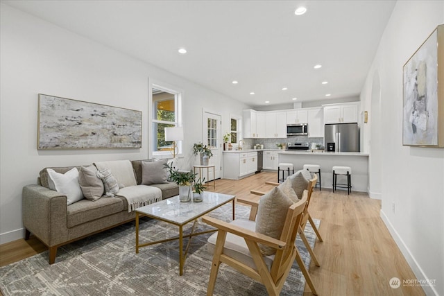 living room with sink and light hardwood / wood-style flooring