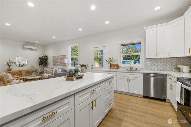 kitchen featuring white cabinetry, dishwasher, plenty of natural light, and light hardwood / wood-style floors