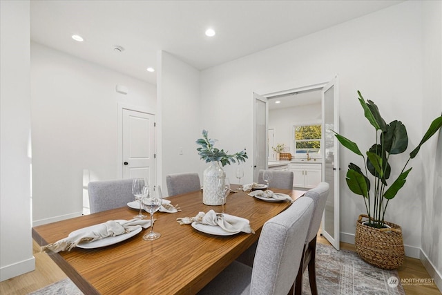 dining room featuring sink and light hardwood / wood-style flooring