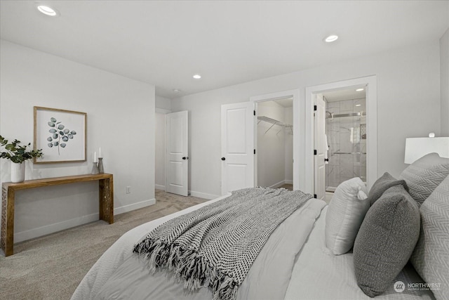 carpeted bedroom with a spacious closet and ensuite bathroom