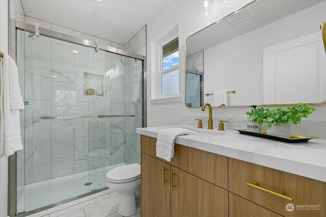 bathroom featuring vanity, toilet, and a shower with door