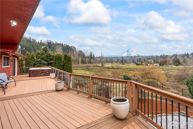 wooden deck with a hot tub and a mountain view