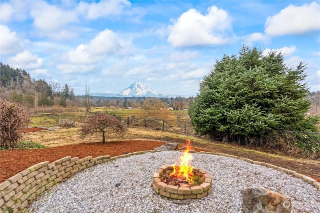 view of yard featuring a mountain view and an outdoor fire pit