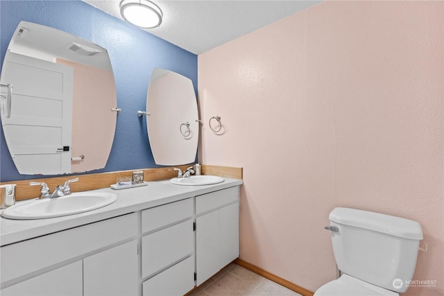 bathroom with vanity, tile patterned flooring, and toilet