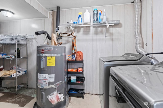 laundry room with secured water heater and washer and clothes dryer