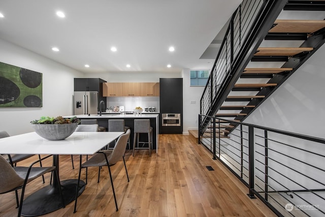 dining area featuring sink and light hardwood / wood-style floors