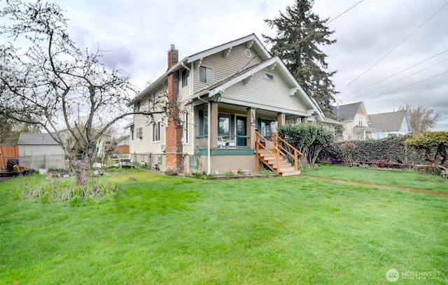 view of front facade featuring a porch, a chimney, a front lawn, and fence