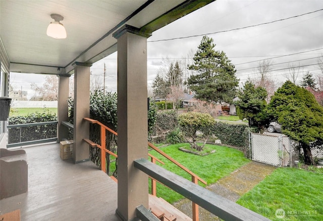 wooden terrace featuring a yard and a porch