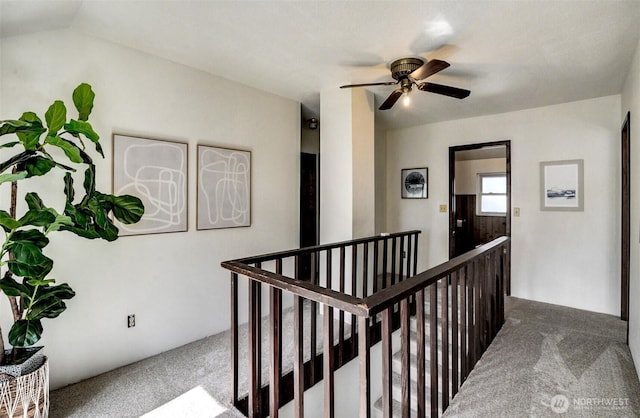 hallway featuring lofted ceiling, an upstairs landing, and carpet