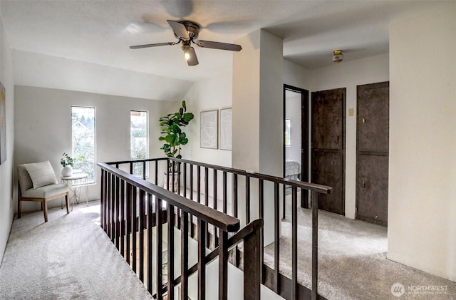 hallway featuring carpet floors, lofted ceiling, and an upstairs landing