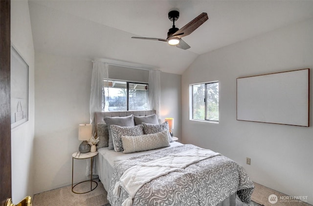 carpeted bedroom featuring lofted ceiling and a ceiling fan